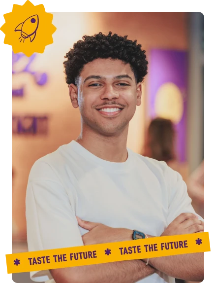 Foto de um jovem sorrindo, com selo de foguete e faixa ‘Taste the Future’